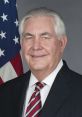 Rex Tillerson, former U.S. Secretary of State, in formal attire with an American flag background.