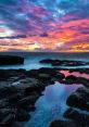 Vibrant sunset over rocky coastline, reflecting stunning colors in tidal pools, creating an amazing coastal landscape.