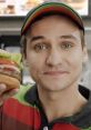 Enthusiastic employee showcasing a delicious Burger King burger, highlighting fresh ingredients and memorable branding.