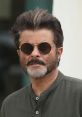 Anil Kapoor sporting sunglasses and a stylish beard, exuding charm and sophistication in a casual outfit.