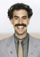 Borat's iconic smile and distinctive mustache in a light gray suit, capturing his hilarious personality and charm.