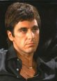 Tony Montana in a dramatic scene from Scarface, showcasing his intense expression and iconic fashion style.