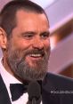 Jim Carrey smiling with a beard at the Golden Globes, reflecting on his comedic legacy from Dumb and Dumber.