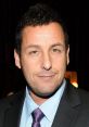 Adam Sandler smiling in a formal suit and tie at an event, showcasing his renowned comedic charm and style.