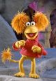 Colorful puppet character with fluffy yellow hair and red outfit, bringing joy and fun, similar to Cookie Monster's playful spirit.