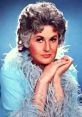 Bea Arthur posing elegantly in a light blue outfit, known for her iconic roles and views on marijuana advocacy.