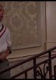 Billy Madison scene featuring a character on a staircase with floral wallpaper, representing the film's comedic moments.