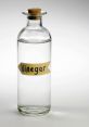 Clear glass bottle with cork stopper labeled "Vinegar," showcasing its versatile and essential culinary use.