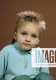 Child with a stylish spiky hairstyle, wearing a light blue polo shirt, looks directly at the camera with curious eyes.