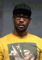 Rapper wearing a yellow shirt featuring Bruce Lee, promoting martial arts culture and honoring the legendary icon.