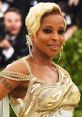 Mary J. Blige dazzles in a gold-embroidered gown, showcasing her stunning style and confidence at a high-profile event.