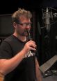 Voice actor in a recording studio, holding a drink while preparing to voice Pickle Rick for an animated series.