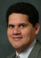 Reggie Fils-Aimé smiling, wearing a suit, known for his influential role at Nintendo and gaming industry leadership.