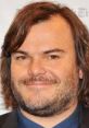 Jack Black smiling at a promotional event, showcasing his signature style and charismatic personality.