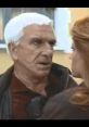 Leslie Nielsen in a tense scene from "Naked Gun," showcasing his iconic comedic style and dramatic expressions.