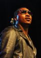 Future performing on stage, wearing sunglasses and a leather jacket, showcasing style and confidence in hip-hop culture.