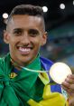 Smiling athlete in green and yellow attire proudly displaying a gold medal, celebrating sports achievements and victory.