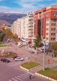 Urban street scene showcasing modern buildings, traffic lights, shops, and pedestrians in a lively city environment.