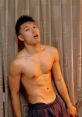 Shirtless small Asian boy posing confidently in front of curtains, showcasing a fit physique and playful expression.