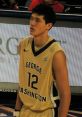 George Washington University basketball player in gold uniform, number 12, during a game, focused on the action.