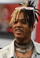 XXXTENTACION sporting unique hairstyle and stylish jewelry, showcasing his iconic look and bold fashion choices.