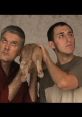 Two men hilariously holding a pet, looking confused, reminiscent of iconic scenes from "Dumb and Dumber" prank calls.