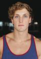 Logan Paul with tousled hair and striking blue eyes, wearing a blue tank top against a dark background.