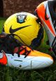 Nike soccer cleats and a vibrant Premier League ball resting on grass, ideal for Adidas Power Soccer enthusiasts.