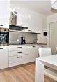 Modern kitchen design featuring sleek cabinetry, stainless steel appliances, and stylish dining table in a welcoming space.