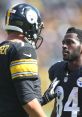 Pittsburgh Steelers players engaged in serious discussion on the field during a game, showcasing teamwork and strategy.