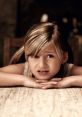 Concerned girl resting her head on a wooden table, expressing uncertainty, perfect for showcasing childhood emotions.