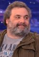 Artie Lange laughing during a talk show interview, showcasing his comedic charm and engaging personality.