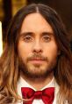 Jared Leto with long hair and a beard, wearing a red bow tie, portraying Jesus in Family Guy episodes.