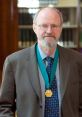 Portrait of a distinguished man wearing a medal, showcasing achievements and contributions in his field, possibly academia.