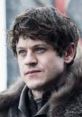 Ramsay Bolton with a cold stare, wearing fur, embodies his ruthless character from Game of Thrones.