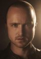 Jesse Pinkman with a serious expression, showcasing his iconic short hairstyle and intense gaze in dramatic lighting.