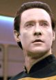 Commander Data from Star Trek: TNG with distinctive yellow eyes and a thoughtful expression, set against the starship backdrop.