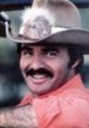 Smiling man in a cowboy hat, reminiscent of Burt Reynolds in "Smokey and the Bandit," showcasing a classic look.