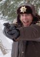 Police officer in Fargo, armed and shouting, stands ready to confront danger in a snowy landscape.