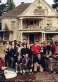 Group of college students celebrating in front of the iconic house from the classic film Animal House.