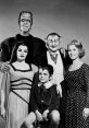 Iconic cast of "The Munsters" TV show, featuring classic characters in a vintage black and white portrait.