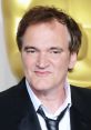 Quentin Tarantino smiles at the Oscars, showcasing his iconic style and charismatic personality at the prestigious awards ceremony.