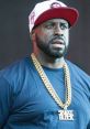 Funkmaster Flex showcasing style with gold chains and a cap, embodying street culture and music influence.