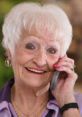 Smiling elderly woman talking on a phone, showcasing warmth and connection, perfect for Phone Line Felicia 2.5.