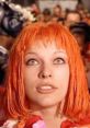 Leeloo from "The Fifth Element" gazes upwards, showcasing her vibrant orange hair and striking blue eyes in a vivid scene.