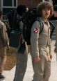 Dustin Henderson wears a Ghostbusters costume with a proton pack, showcasing adventure spirit in Stranger Things.