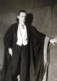 Bela Lugosi in classic Dracula attire, exuding mystery and elegance with a dramatic cloak and sharp formal wear.