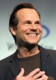 Bill Paxton smiling at an event, showcasing his charismatic personality and engaging presence. Iconic actor and director.