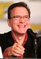 Billy West laughing during a panel discussion, showcasing his vibrant personality and engaging presence in entertainment.