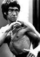 Bruce Lee demonstrating martial arts techniques, showcasing his athleticism and fierce concentration in black and white.